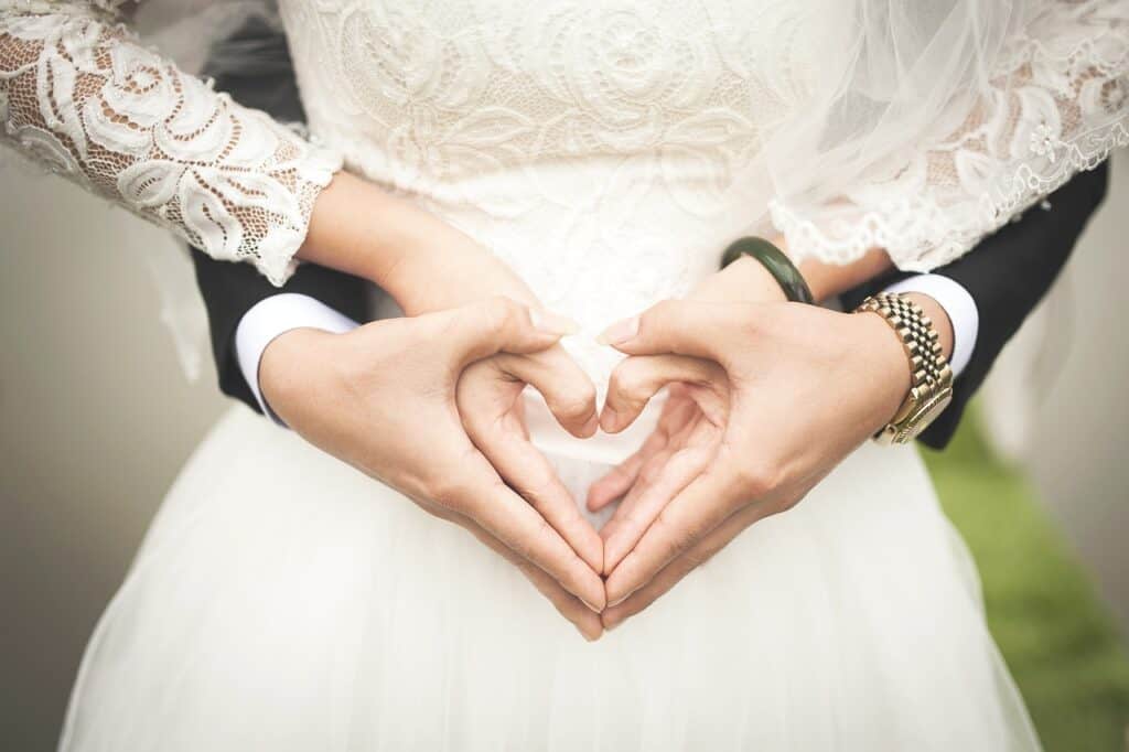 Husband and wife just married holding hands in shape of a heart