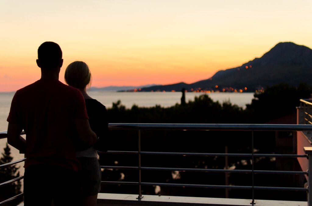 pensive husband and wife looking out at harbor