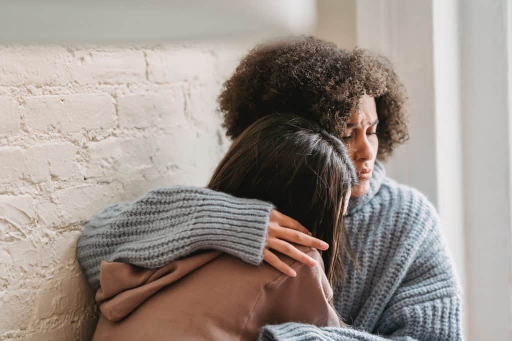 mom comforting teen girl