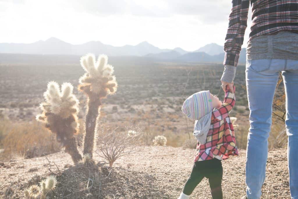 mom holding toddler's hand in desert