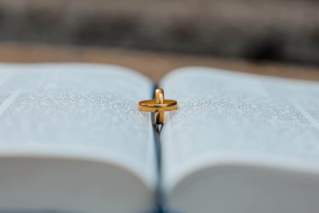 Two gold wedding rings sit on an open book