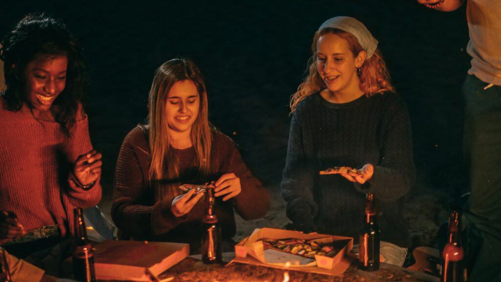 young women eating pizza and drinking beer