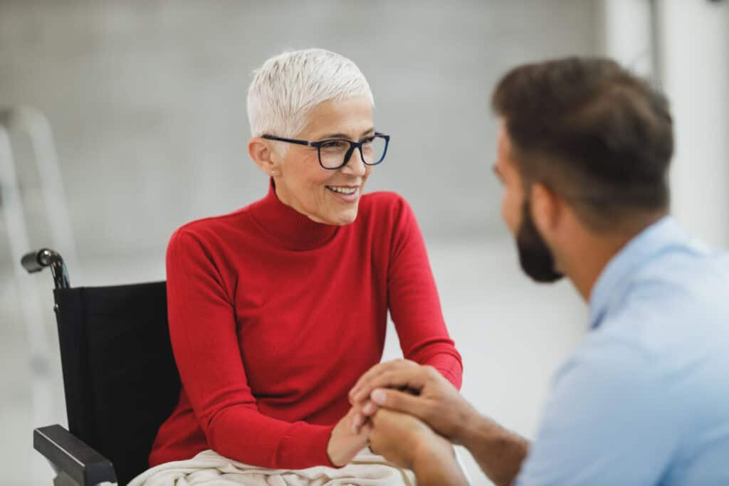 Woman in wheelchair talking to medical professional