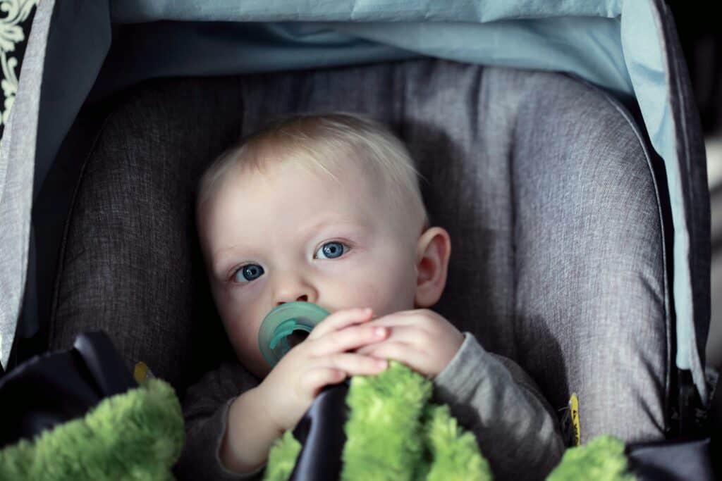 boy in carseat with pacifier