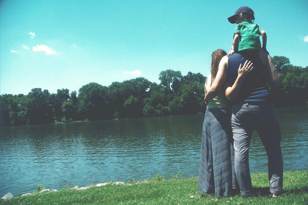 couple with young child by lake