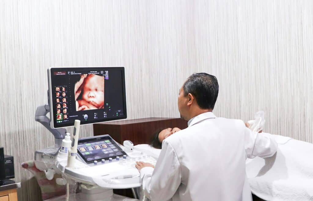 doctor doing ultrasound picture of baby on screen