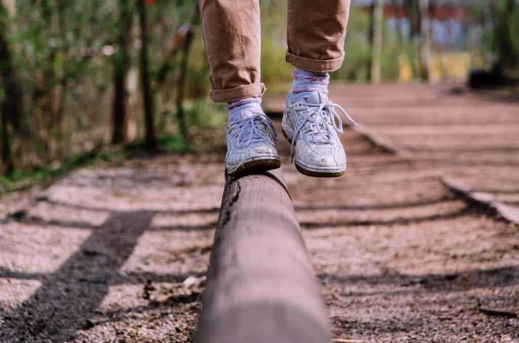 feet in sneakers balancing on a log