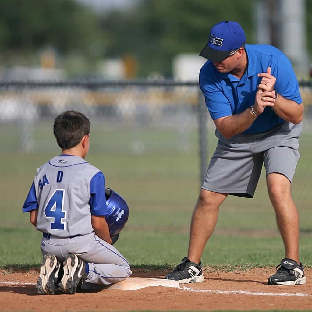 man shows boy how to bat