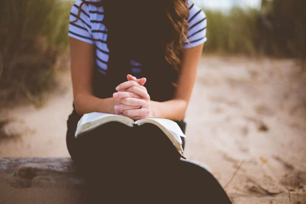 woman praying holding Bible