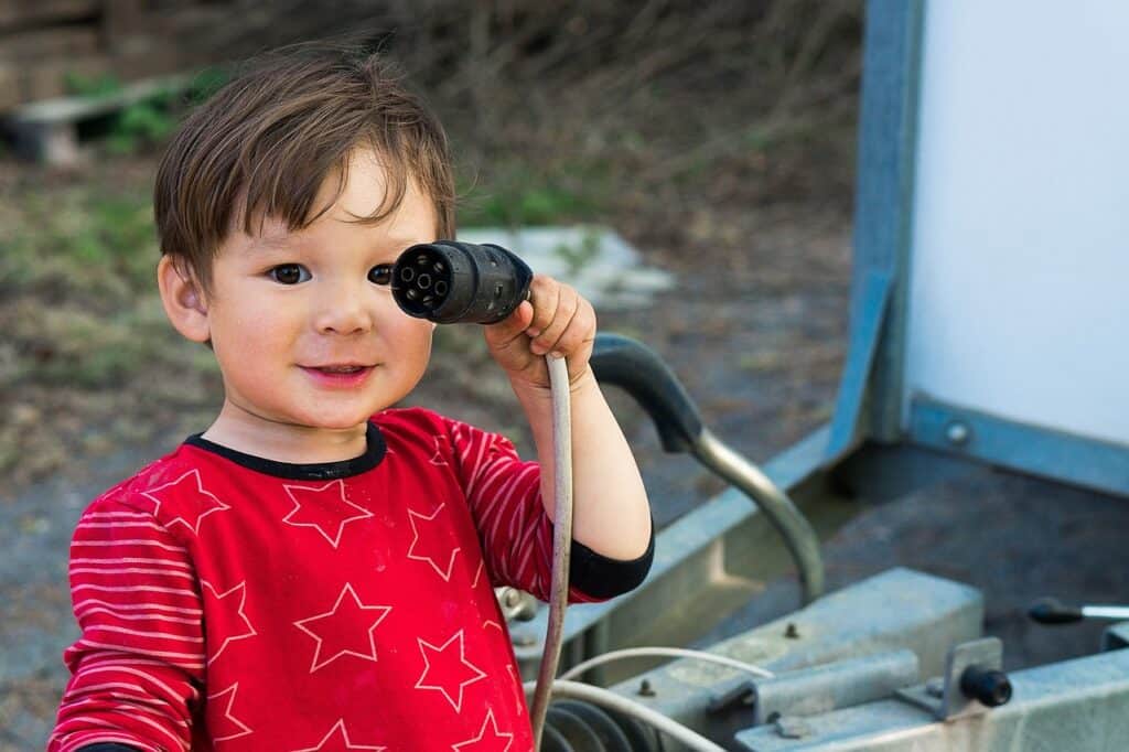 little boy pointing hose at camera