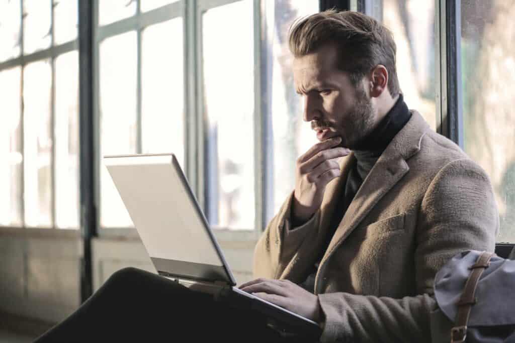 man with laptop looking puzzled