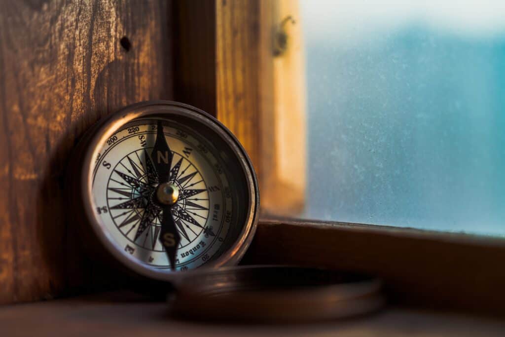 A compass sits in a window