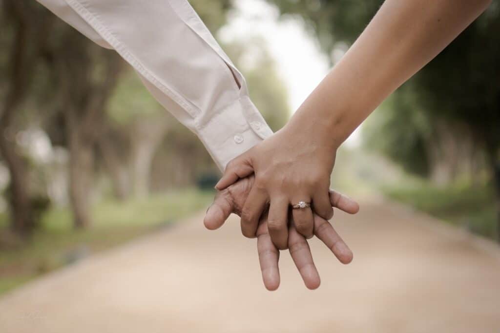 male and female holding hands wedding ring