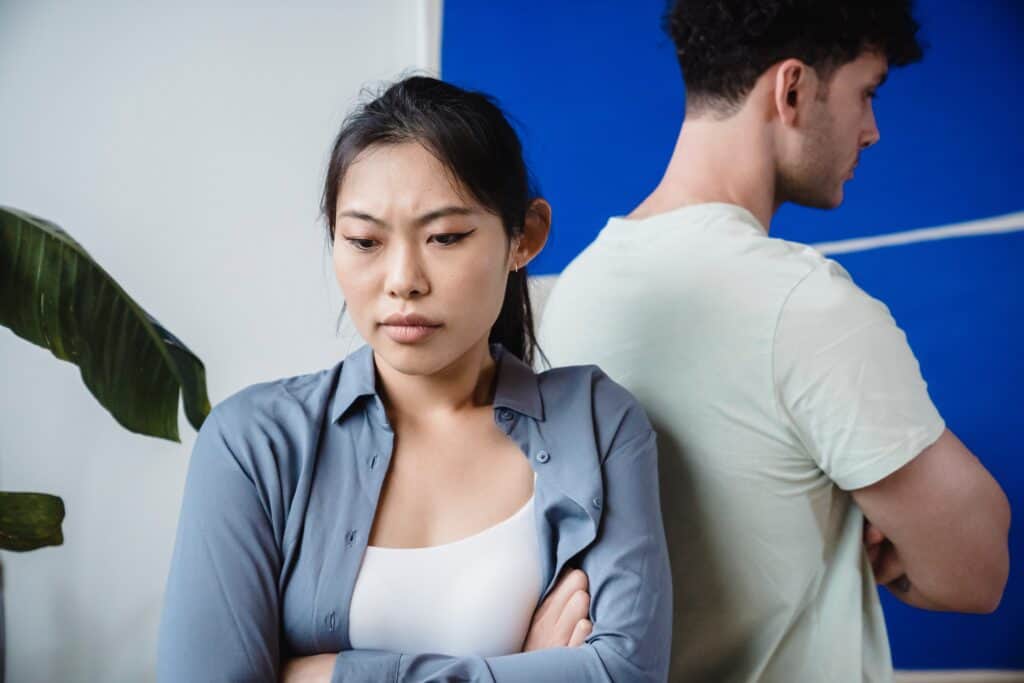 A husband and wife are angry with each other and standing back to back