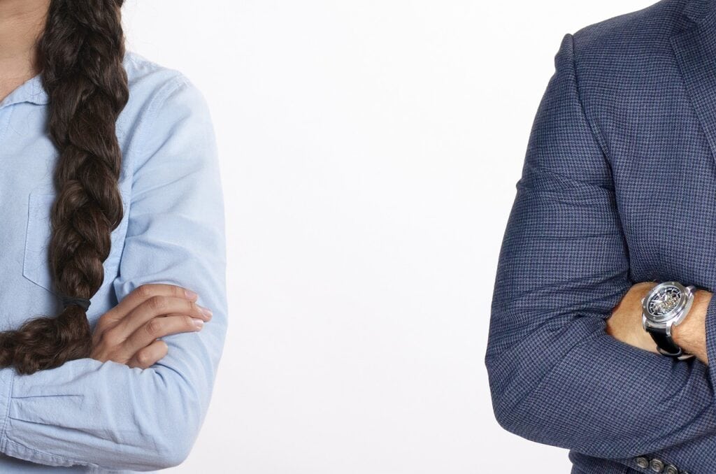 arms of man and woman folded standing apart angry