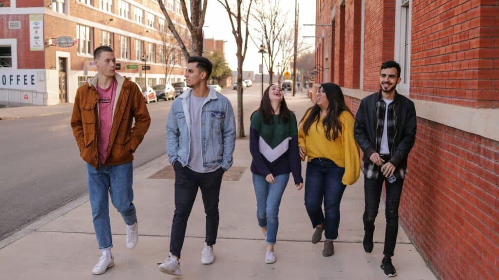 Teens three guys two girls walking down street