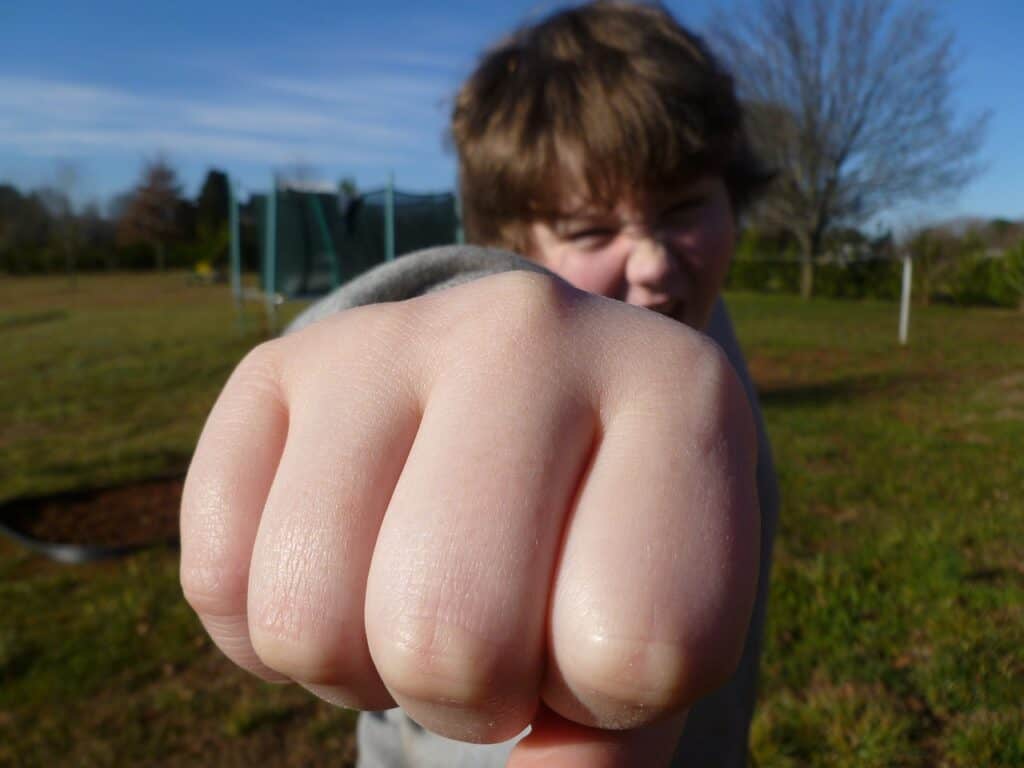 boy with fist stretched out to punch