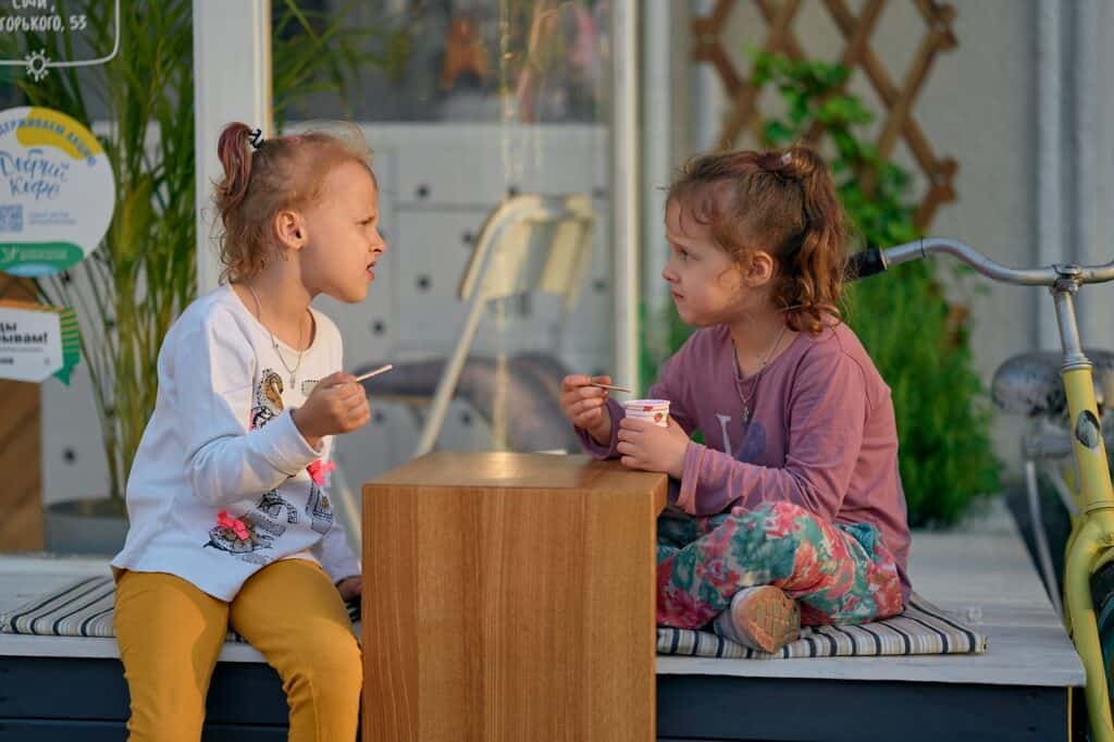 Two girls eating one looks angry
