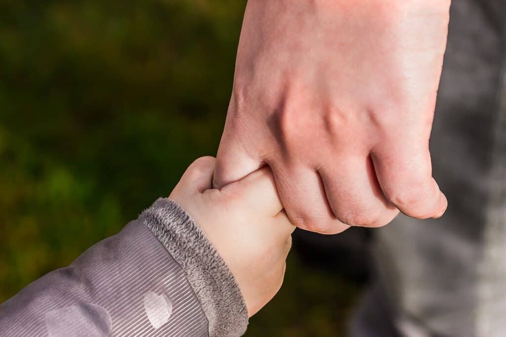 adult hand holding small hand