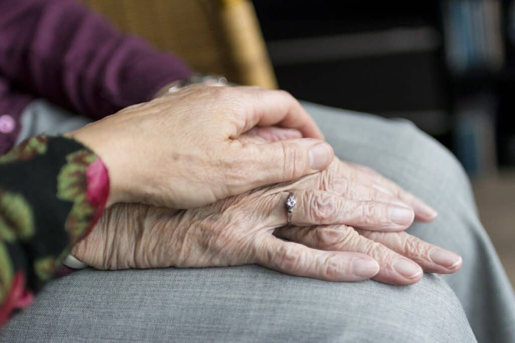 Younger female hand holding older female hand