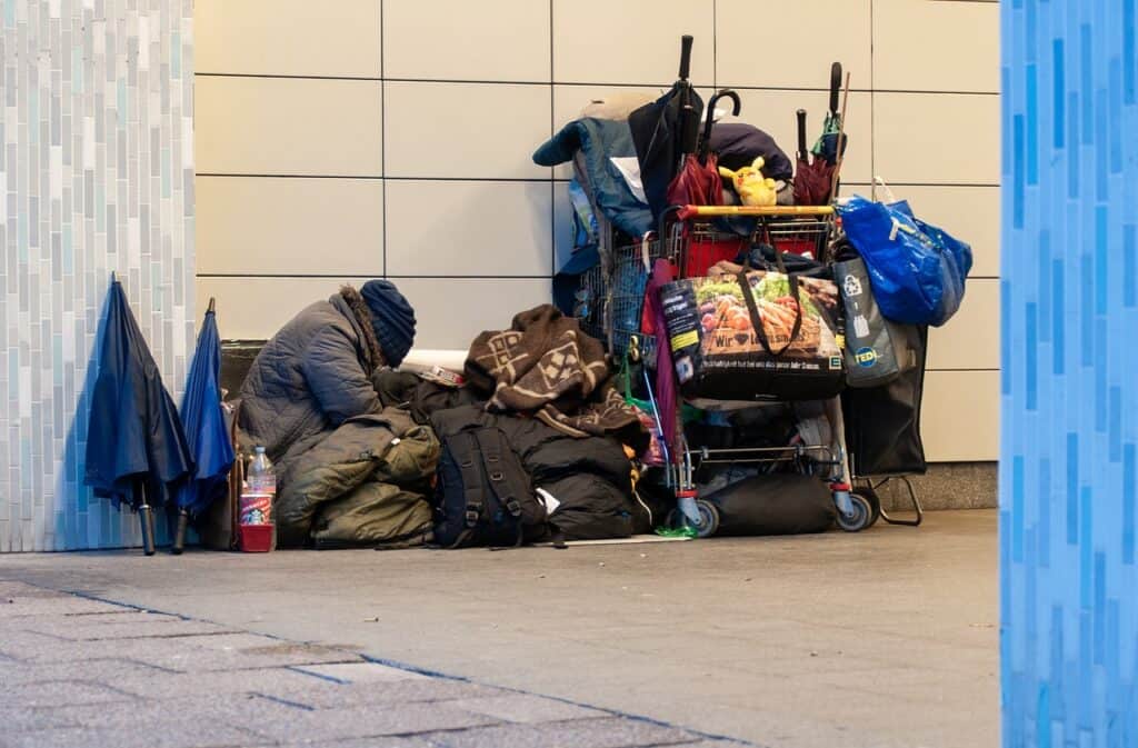 homeless man with shopping cart full of things