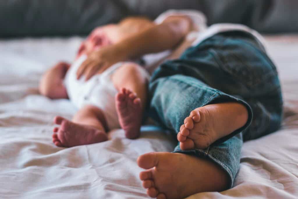 feet of baby and toddler lying down