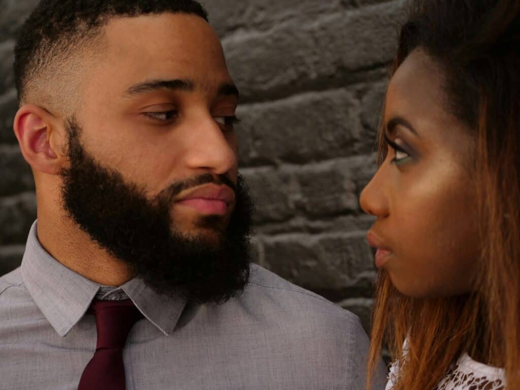 man and woman looking at each other standing close