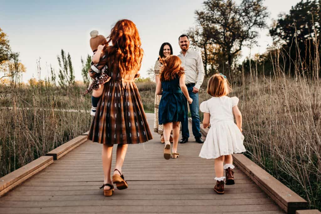 parents waiting on bridge for four young children