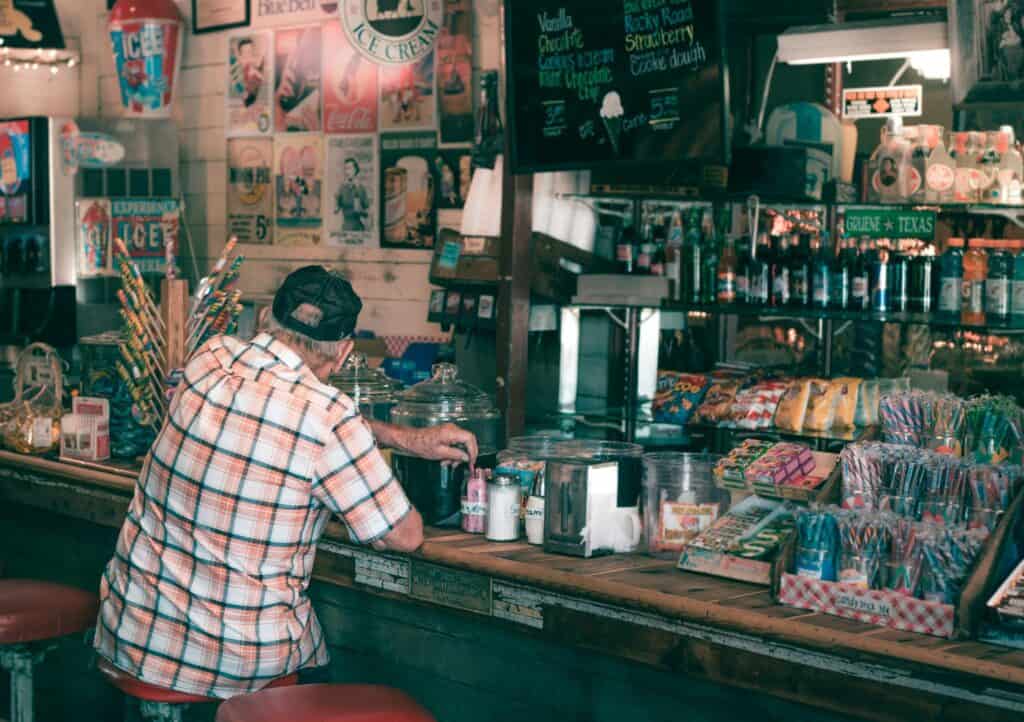 older man sitting at counter in soda shop