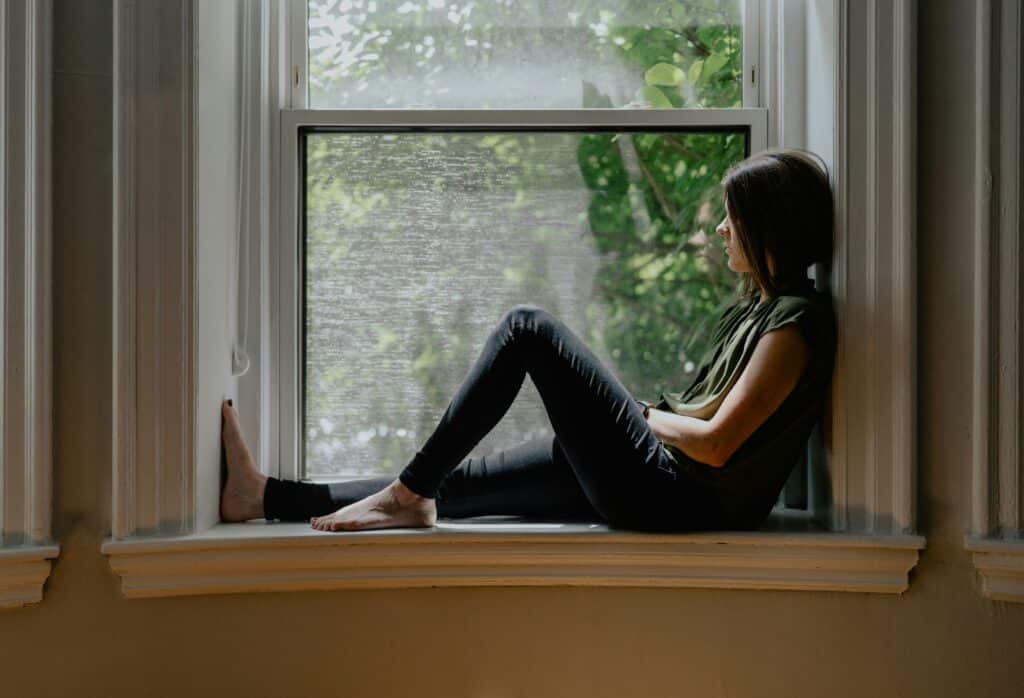 teen girl sitting in window