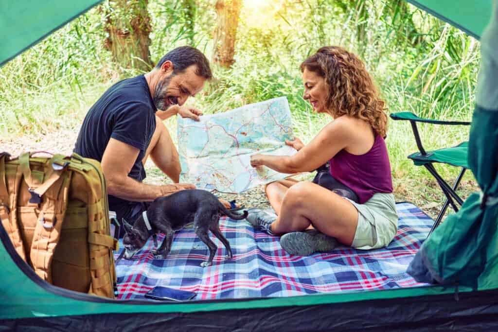 middle age man and woman camping with dog