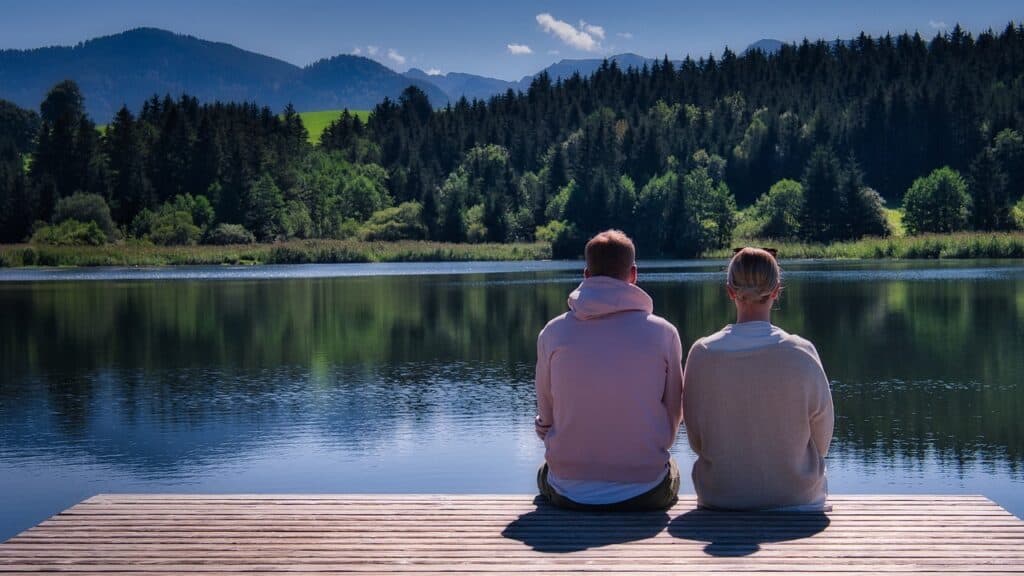 couple looking our over lake side by side