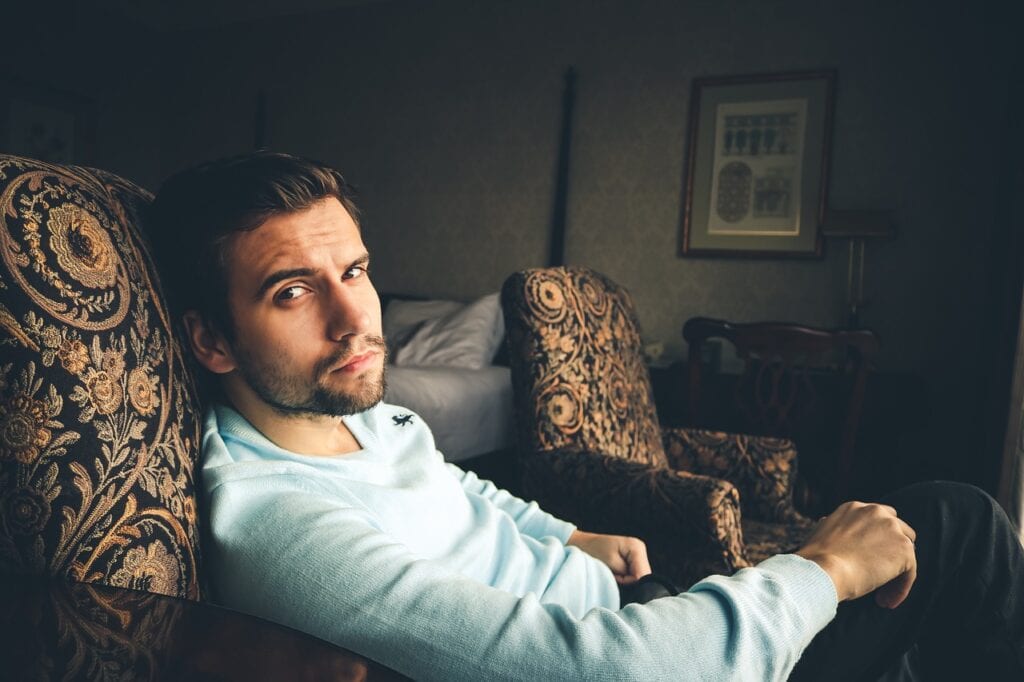 young adult man in chair looking at camera