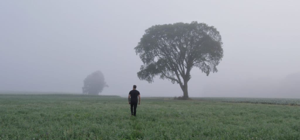 man walking away into fog