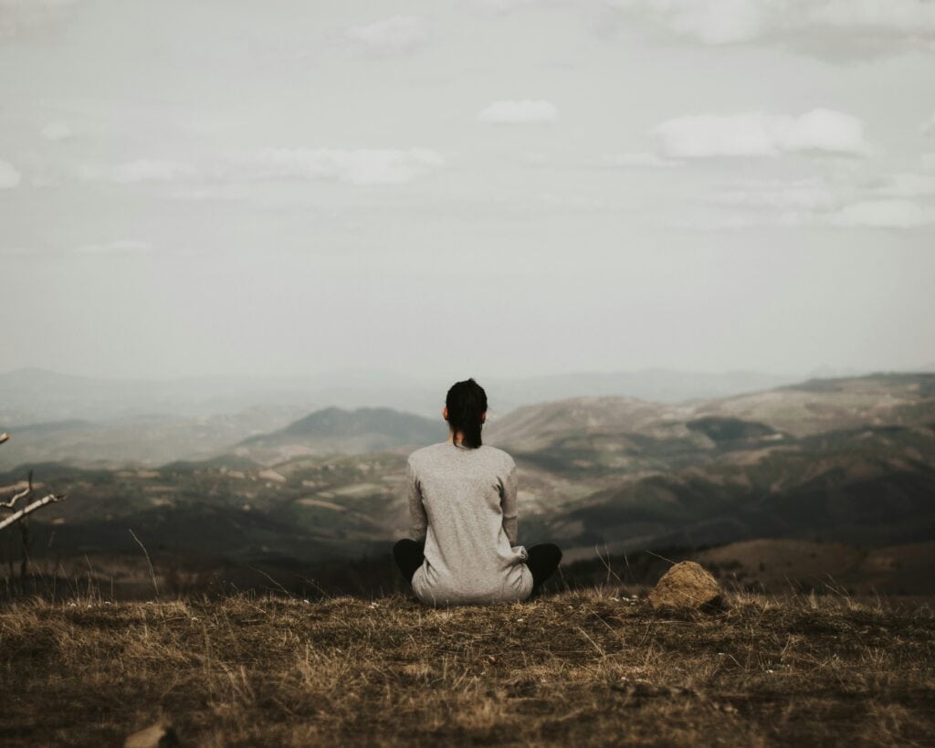 woman looking out over mountains contemplating