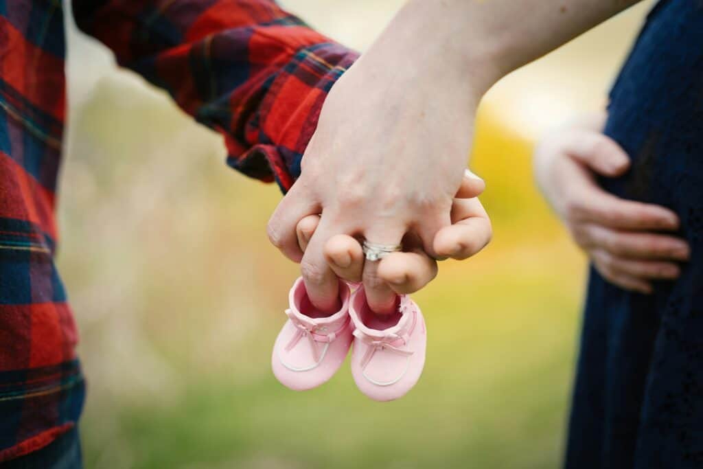 couple with baby shoes woman pregnant