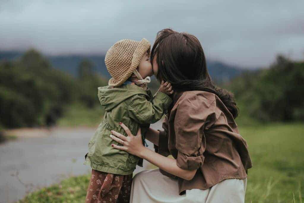 little girl kissing mom's cheek