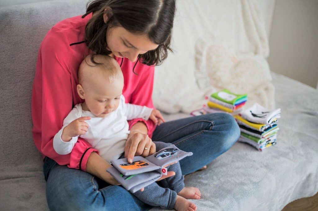 mom reading cloth books to toddler