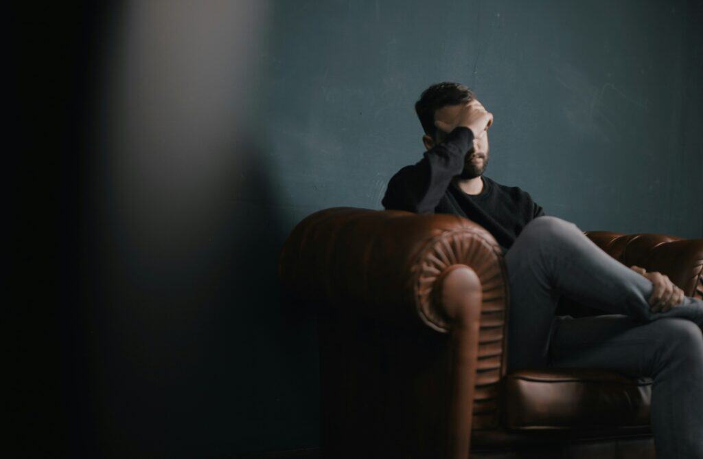 upset man sitting on therapist couch