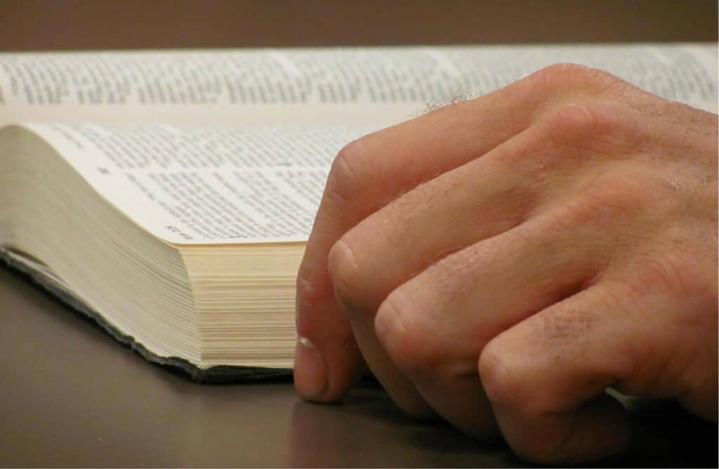 hand next to open Bible