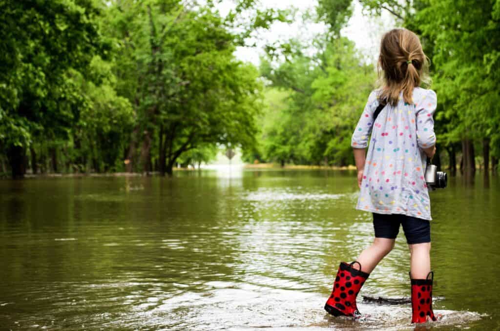 girl in boots looking at flooded street