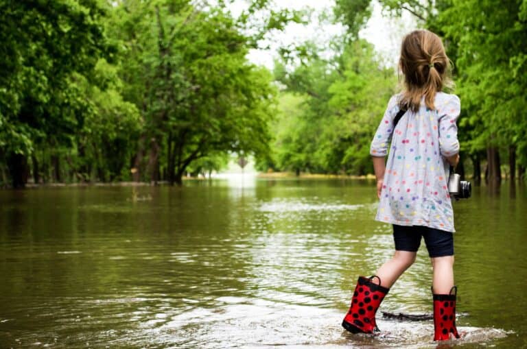 girl in boots looking at flooded street