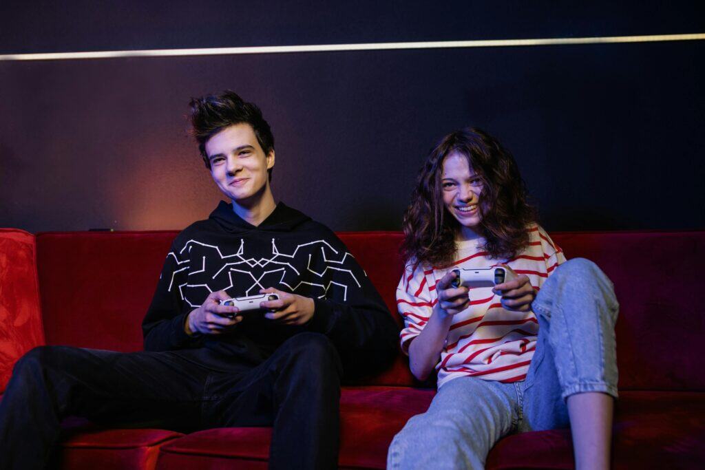 teen guy and girl on couch playing video game