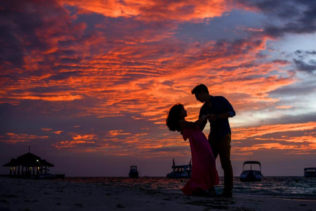 man woman shadows on beach at sunset