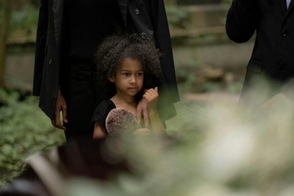 little girl with stuffed animal everyone in black