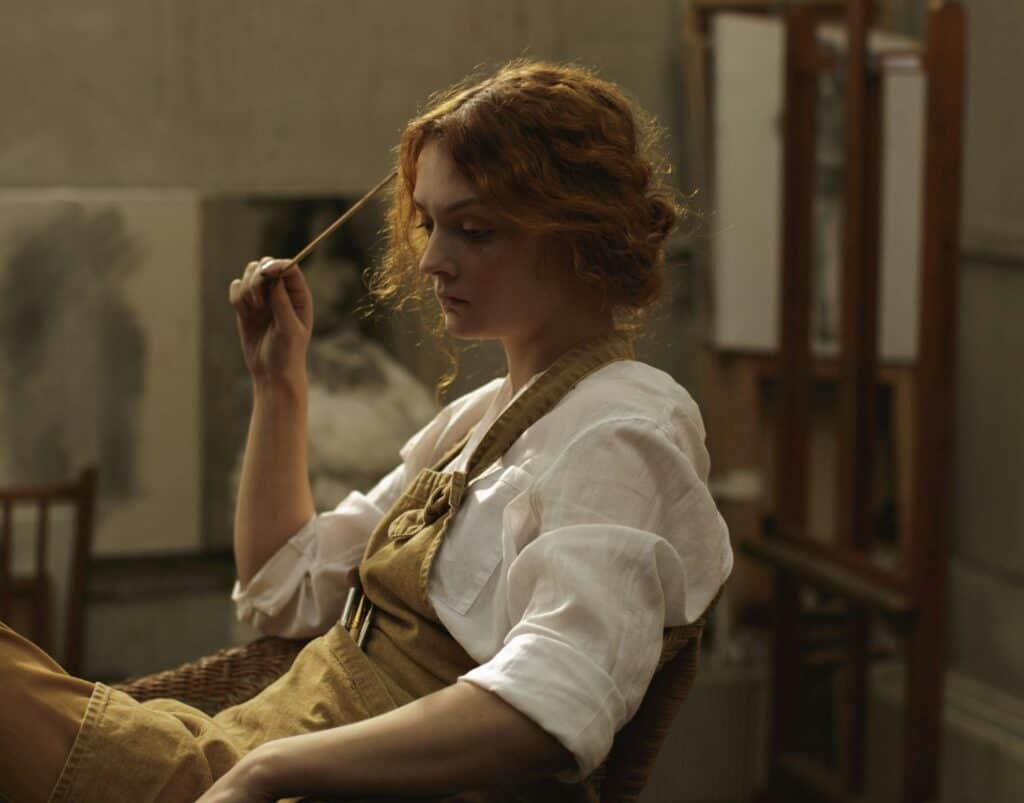 young woman sitting in chair staring off sad