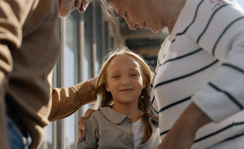Little girl smiling between grandparents