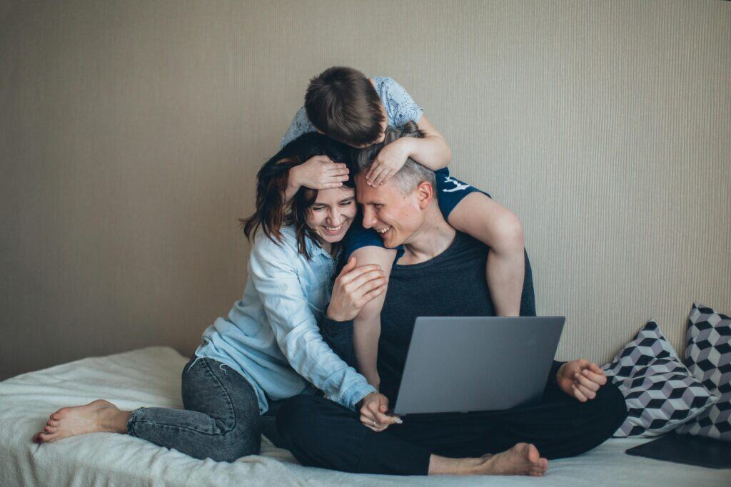 husband wife and child looking at computer