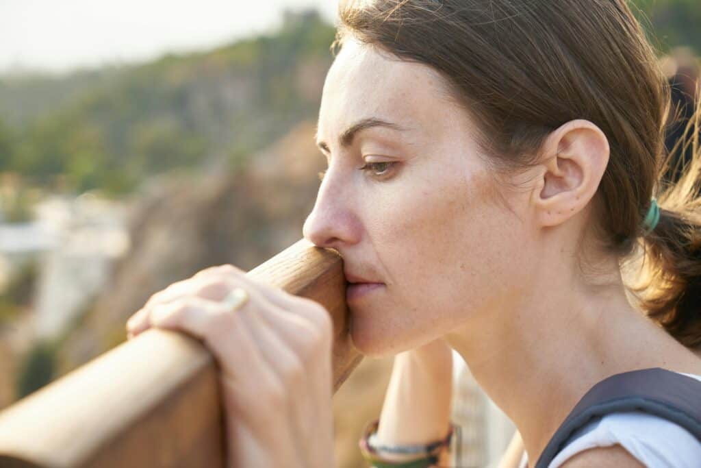 sad discouraged woman leaning on railing
