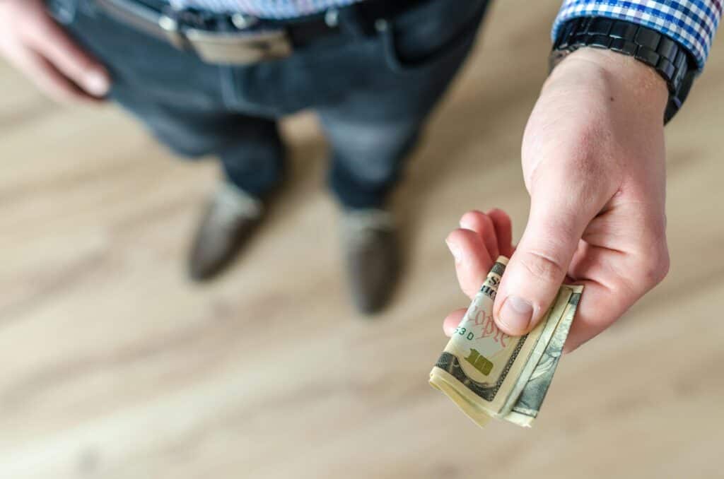 man's legs hand holding usd ten dollars